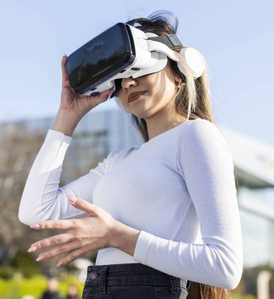 Young lady wears virtual reality glasses at the street. High quality photo